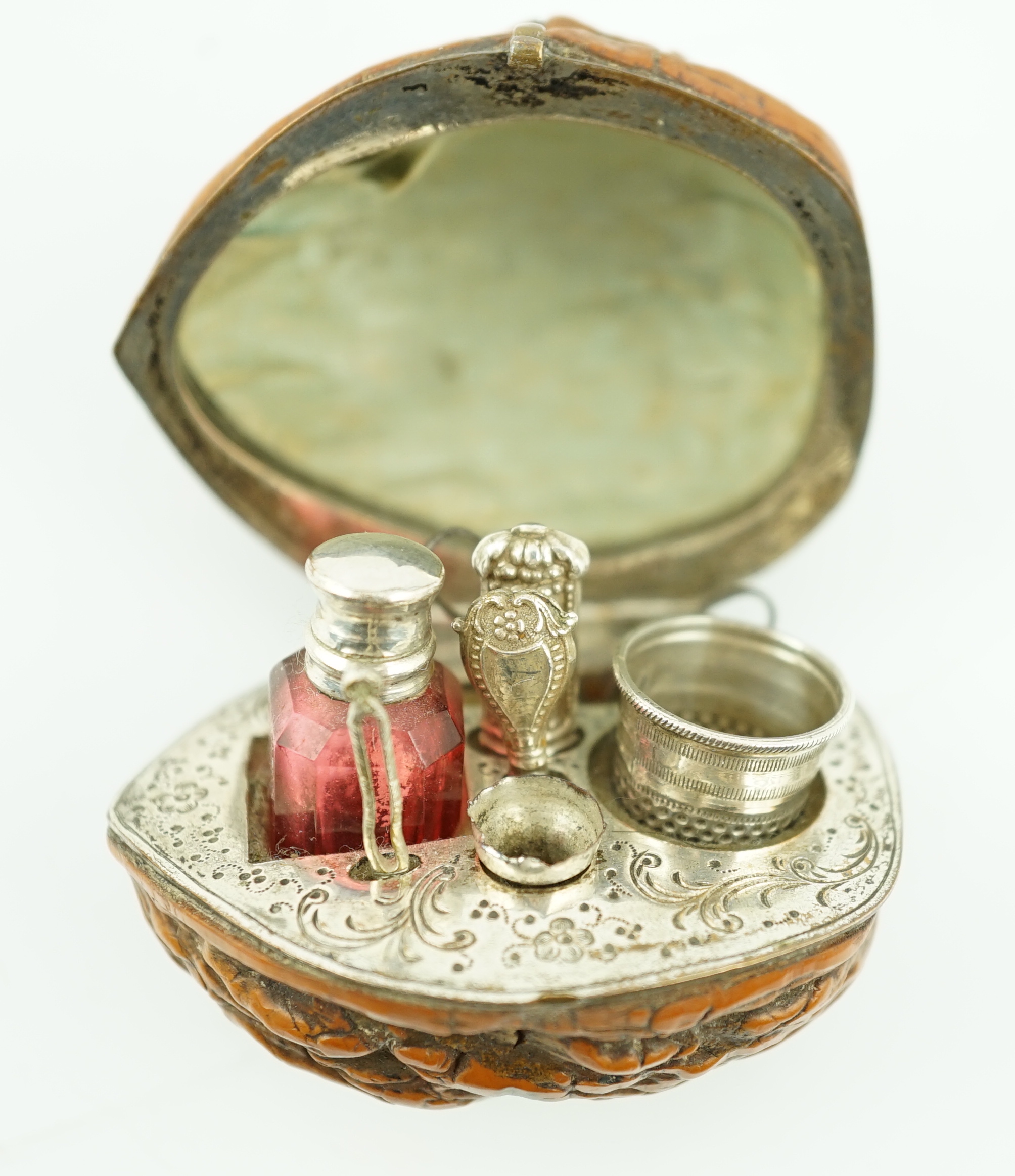 A 19th century French novelty etui case, modelled as a walnut, containing six silver or silver mounted implements